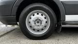 Close-up of a front wheel of a 2017 Ford Transit featuring a silver alloy rim and a black tire with a tread pattern