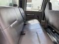 The interior of a 2010 Ford F-550 showing a gray leather back seat with seat belts and textured flooring