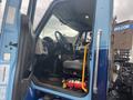 The interior of a 2016 International 7400 truck featuring a driver's seat a steering wheel and control panels visible