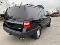 A 2017 Ford Expedition in black color with chrome accents parked at an outdoor lot showcasing its SUV design and rear features