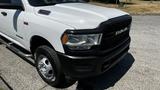 A 2019 RAM 3500 pickup truck with a white exterior black grille and chrome accents parked on a concrete surface