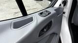 Interior door panel of a 2017 Ford Transit featuring a gray finish with a cup holder and door handle