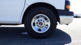 A 2012 GMC Savana with a shiny chrome wheel and black tire viewed from the side