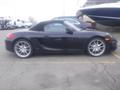 A black 2016 Porsche Boxster with a convertible top and five-spoke alloy wheels parked on a lot