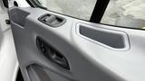 Interior door panel of a 2017 Ford Transit featuring a smooth texture with a door handle and control buttons for the windows and locks