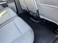 The interior of a 2019 Ford F-350 SD showing the backseat and floor mat with textured fabric seats