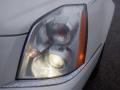 Close-up of a 2008 Cadillac Limousine headlight with a slightly foggy lens showcasing an orange turn signal and reflective chrome detailing