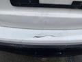 A close-up of a 2016 Mazda CX-5's rear bumper showing a long crack and scratches on the surface