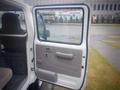 A 2003 Toyota Toyoace with its driver's side door open showing the interior door panel and seating area