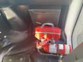 A red bag with a silver zipper sits next to a fire extinguisher inside a 2018 Chevrolet Express vehicle