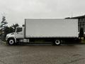 A white 2020 Hino 338 box truck is positioned sideways with a tall cargo area and a cab in the front featuring a distinct grille and headlights