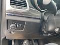 A close-up view of the interior controls of a 2018 Jeep Grand Cherokee featuring a dial for headlights and a switch for interior lighting