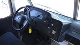 Interior view of a 2011 Ford Econoline dashboard featuring steering wheel control panel and various switches and instruments