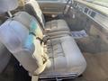 Interior view of a 1982 Mercury Grand Marquis featuring plush beige front seats with seat belts and a wooden dashboard