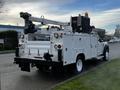 A 2018 Ford F-550 with a utility body featuring an aerial work platform and tools mounted on the rear