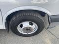 Close-up of the tire and wheel rim of a 2018 Chevrolet Express showing a light gray color and a rugged tire tread pattern