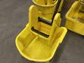 Ten yellow mop buckets with one featuring a wringer attachment and assorted brooms leaning against them