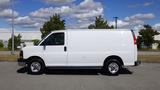 A white 2015 GMC Savana van viewed from the side with a simple design and black wheels