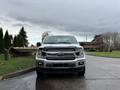 A 2018 Ford F-150 pickup truck facing the camera with a silver exterior and black accents