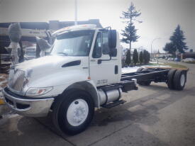 A 2013 International DuraStar 4300 truck with a white cab and chassis featuring large front headlights and a prominent grille