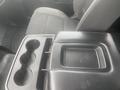 Interior view of a 2015 Chevrolet Silverado 3500HD showing the center console with cup holders and a flat storage area