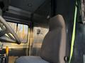 Interior view of a 2017 Freightliner M Line showing the driver's seat and steering wheel with a green safety strap attached to the passenger side