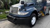 A blue 2009 International 4300 truck with a prominent grille and large front bumper featuring side mirrors and detailed headlights