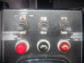 Control panel of a 2008 International 7400 featuring three toggle switches and three indicator lights in red and green