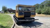 A 2015 PowerBully Tracked Flat Deck Equipment Carrier with a yellow and black exterior featuring a grid-patterned cab and tracked undercarriage