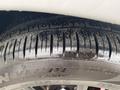 Close-up of a tire from a 2018 Jeep Grand Cherokee featuring a tread pattern and water droplets on the surface