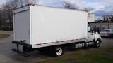 A 2012 International TerraStar truck with a white box cargo area and black bumpers parked on a road