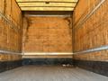 The interior of a 2013 International 4300 box truck with wooden walls and a flat floor showing signs of wear and tear