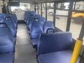 A 2017 Chevrolet Express interior showcasing rows of blue upholstery bus seats with a clear aisle running down the center