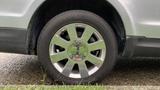 Close-up of a silver 2013 Lincoln MKT wheel with a shiny chrome rim and black tire featuring a Lincoln logo in the center