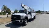 A white 2011 Ford F-450 SD truck with a mounted bucket lift on top and utility compartments on the side