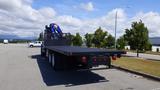 A 2017 Freightliner M2 106 flatbed truck with a blue boom lift attached on the back