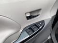 Close-up view of the door panel of a 2013 Toyota Sienna featuring window controls and a handle