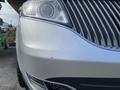 A silver 2013 Lincoln MKT with distinctive front grille and headlight design showing slight markings on the bumper