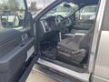 A 2014 Ford F-150's interior showing the driver's seat and dashboard with controls and floor mats visible