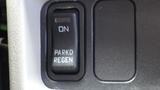 A close-up of a black truck control button labeled PARKD and REGEN with an ON indicator