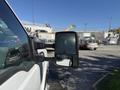 A 2016 Ford F-350 SD with a black side mirror reflecting the surrounding environment