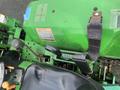 Top view of a green 2003 John Deere 790 tractor dashboard featuring gauges levers and control switches