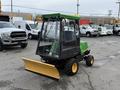 A 1994 John Deere F1145 utility vehicle with a green and yellow color scheme featuring a cab and a front snow plow attachment