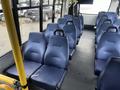 Interior of a 2017 Chevrolet Express with blue vinyl seats arranged in two rows facing each other