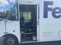 A 1999 Ford Econoline delivery truck with an open door revealing the driver's seat and dashboard interior