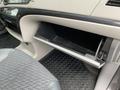 The image shows the open glove compartment of a 2013 Toyota Sienna with a grey interior and textured flooring