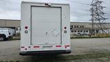 A white 2006 Ford Econoline with a large delivery-style rear door and red reflective markers on the bumper