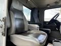 Interior view of a 2014 Kenworth T370 showing the driver and passenger seats with dark leather upholstery and a steering wheel.