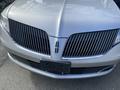 Front view of a silver 2013 Lincoln MKT with distinctive vertical grille bars and logo on the hood