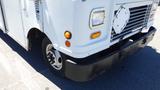 A white 2006 Ford Econoline with a black bumper and round headlights parked on a surface with visible tire and wheel rim